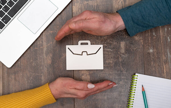 Concept of job loss insurance with hands in a protective gesture