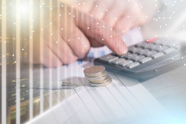 Mali belgeler üzerinde çalışan ve hesap makinesi kullanan bir muhasebecinin elleri