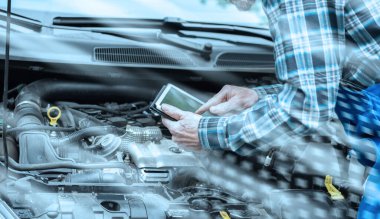 Otomobil tamircisi, araba motorunu kontrol etmek için dijital tablet kullanıyor; ışık efekti