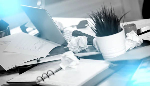 Messy and cluttered office desk; light effect