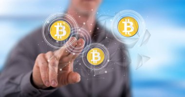 Bir adam dokunmatik ekranda bitcoin para kavramına parmağıyla dokunuyor