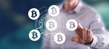 Bir adam dokunmatik ekranda bitcoin konseptine parmağıyla dokunuyor.