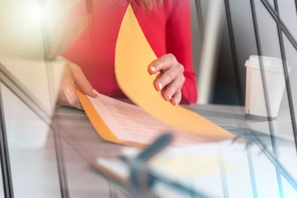 Businesswoman opening folder with paper documents; multiple exposure