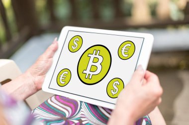 Bir kadının elinde tuttuğu tablette Bitcoin konsepti