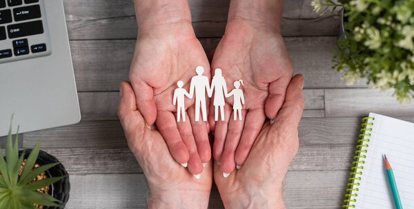 Концепция страхования семьи с бумажной семьей в руках