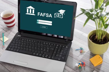 Laptop on a desk with fafsa concept on the screen clipart