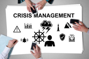 Kriz yönetimi kavramı akıllı telefonları kullanan ellerle masaya yerleştirildi