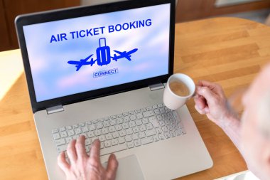 Ekranda uçak bileti konsepti olan bir dizüstü bilgisayar kullanan bir adam.