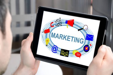 Pazarlama kavramını gösteren bir tablet tutan adam