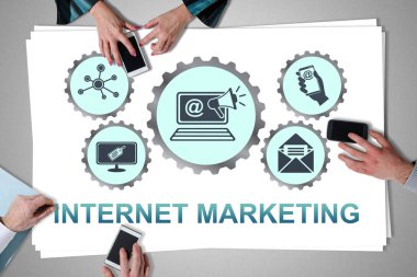 Internet marketing concept placed on a desk with hands using smartphones