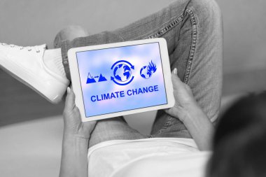 Tablette iklim değişikliği kavramına bakan bir kadın