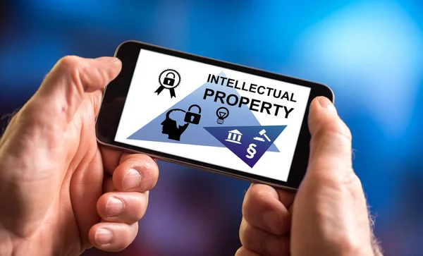 Hand holding a smartphone with intellectual property concept