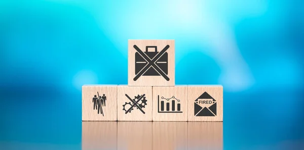 Wooden blocks with symbol of job loss concept on blue background