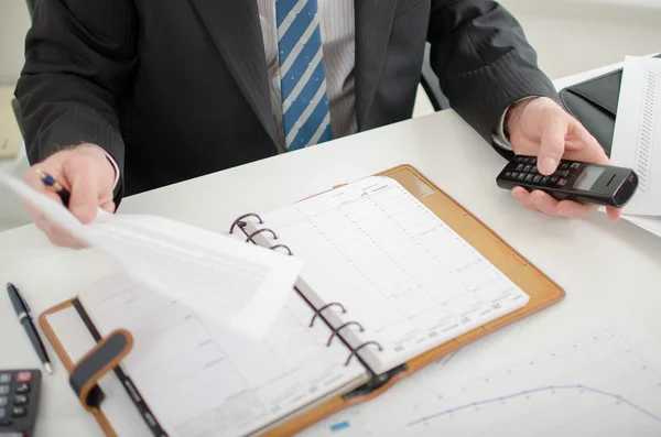 Empresário segurando um documento e um telefone — Fotografia de Stock