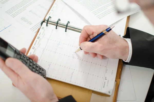 Businessman taking an appointment in his diary — Stock Photo, Image