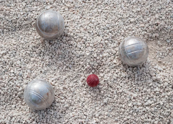 Metallic petanque balls and a small red jack — Stock Photo, Image