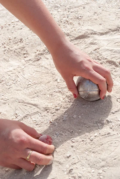 Hands picking up a petanque ball and the jack — Stock Photo, Image