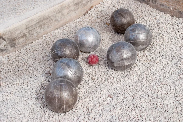 Metallic petanque balls and a small red jack — Stock Photo, Image