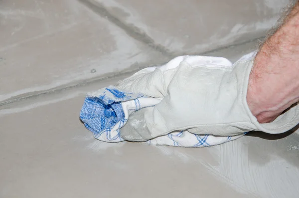 Tiler cleaning tiles after filling up joints — Stock Photo, Image