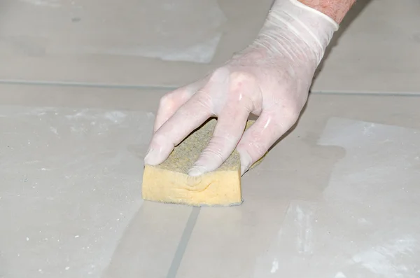 Tiler smoothing tile joints with a sponge — Stock Photo, Image