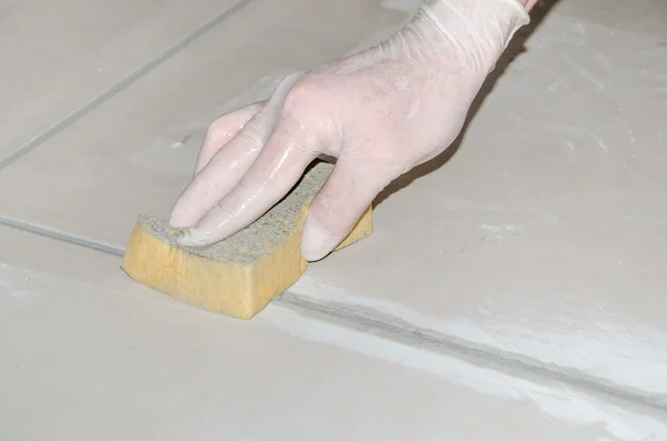 Tiler smoothing tile joints with a sponge — Stock Photo, Image