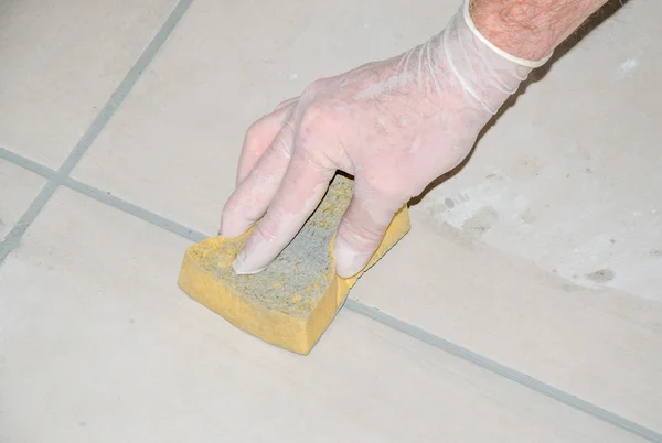 Tiler smoothing tile joints with a sponge — Stock Photo, Image