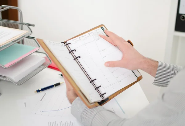 Zakenman raadpleging van zijn agenda — Stockfoto