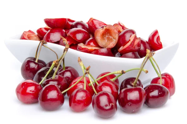 Cup of tasty pitted cherries with whole cherries — Stock Photo, Image