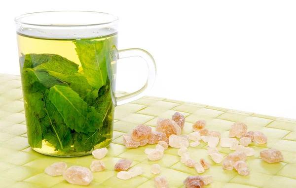 Copa de té de menta con azúcar de caña morena en una alfombra de lugar verde — Foto de Stock