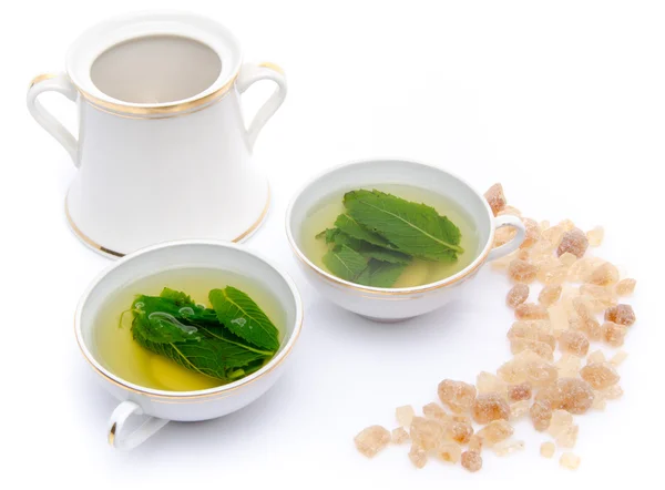 Composition with two cups of mint tea and brown cane sugar — Stock Photo, Image
