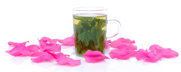 Csésze mentateát rózsaszín szirmok körül — Stock Fotó