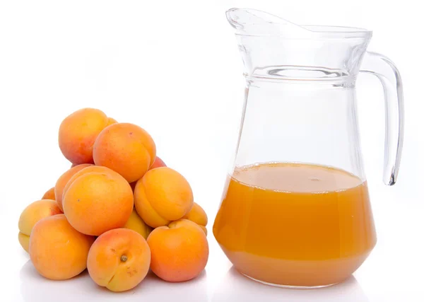 Heap of apricots and a jug of apricot juice — Stock Photo, Image