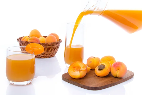 Sammansättning med aprikos juice hälls i ett glas — Stockfoto