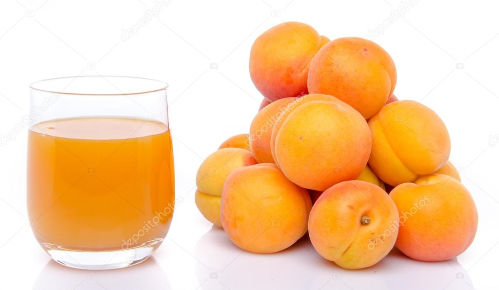 Glass of apricot juice next to a heap of apricots — Stock Photo