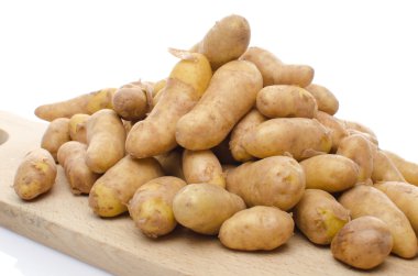 New rattes potatoes on a wooden board clipart