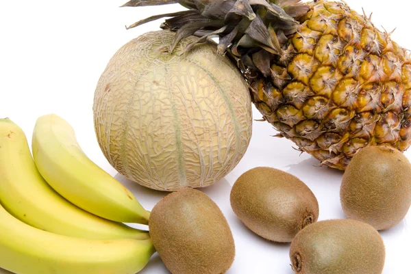 Sammansättning med en ananas, bananer, kiwi och en melon — Stockfoto