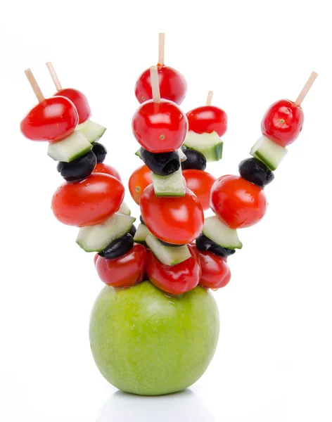 Cherry tomatoes, cucumber and olives on skewers pricked into an — Stock Photo, Image