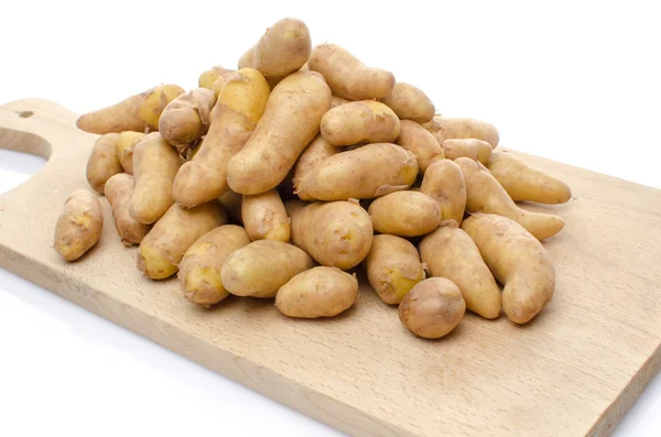 Nieuwe rattes aardappelen op een houten bord — Stockfoto