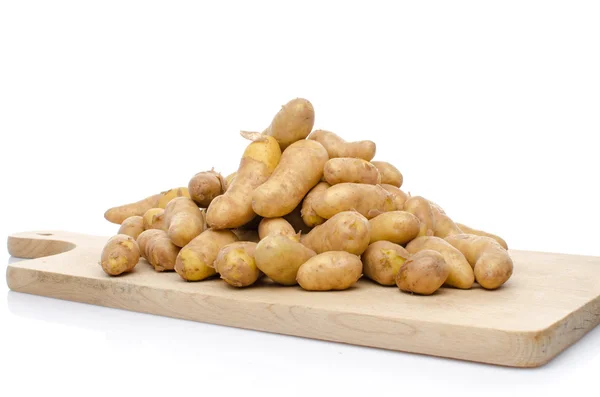 Nieuwe rattes aardappelen op een houten bord — Stockfoto