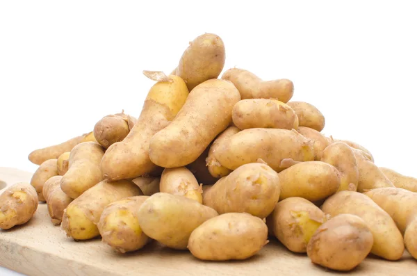 Nieuwe rattes aardappelen op een houten bord — Stockfoto
