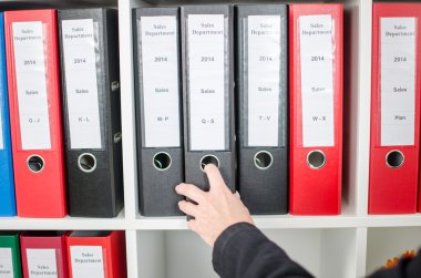 bir klasörü bir raf dışarı çekerek el