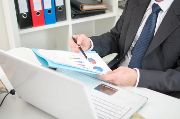 Empresário verificando gráficos financeiros — Fotografia de Stock