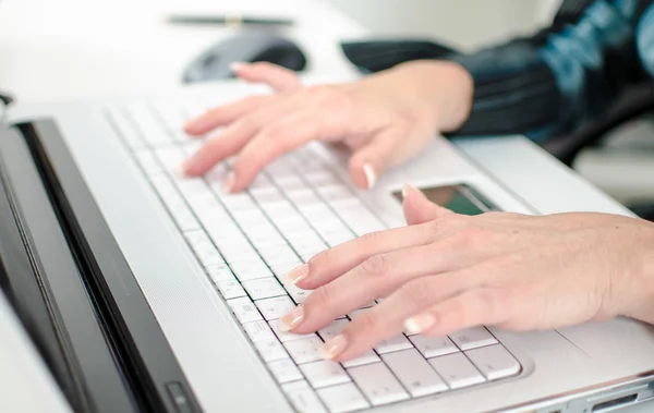 Vrouwelijke handen op een laptop computertoetsenbord te typen — Stockfoto