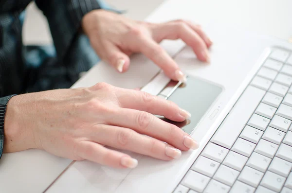 Las manos femeninas trabajando en un teclado de ordenador portátil — Foto de Stock