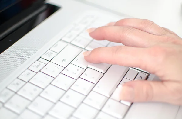 Mão feminina digitando em um teclado branco — Fotografia de Stock