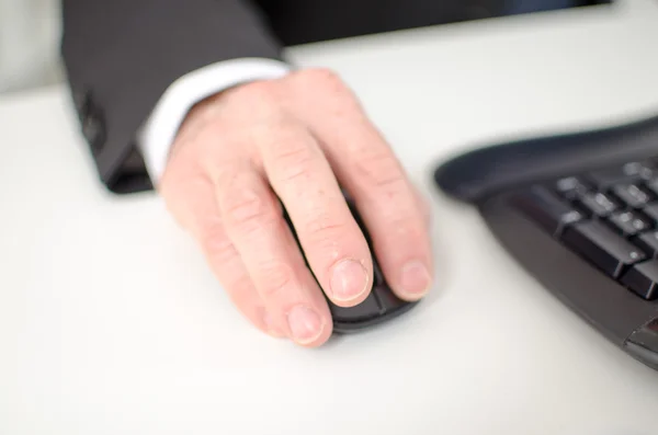 Mão de empresário segurando um mouse de computador — Fotografia de Stock