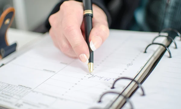 Geschäftsfrau notiert einen Termin in ihr Tagebuch — Stockfoto
