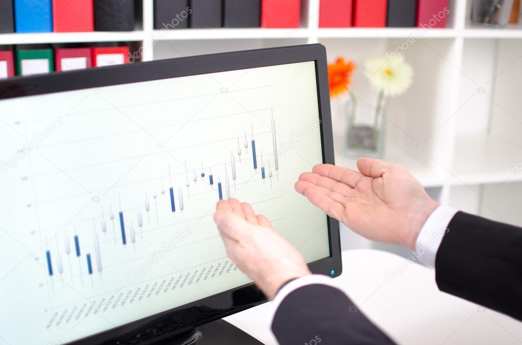 Hands showing a screen with stock exchange data graph