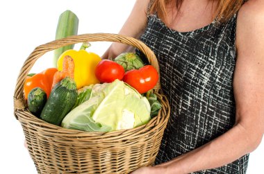 Bir sepet sebze dolu tutan kadın