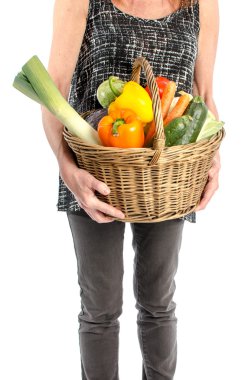 Bir sepet sebze dolu tutan kadın